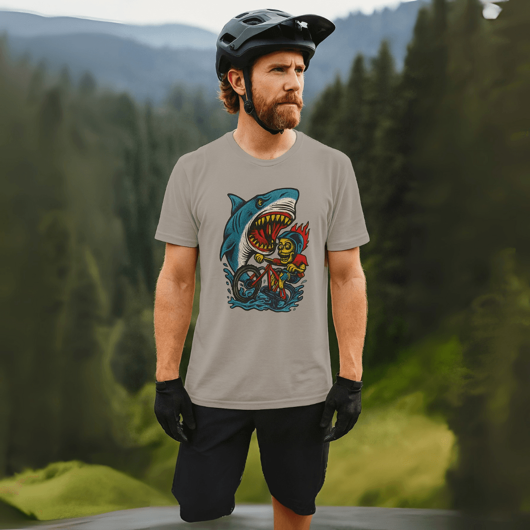 Shark Attack MTB Tee in gray worn by a mountain biker in scenic outdoors. Fun and breathable CVC jersey shirt for adventurous riders.