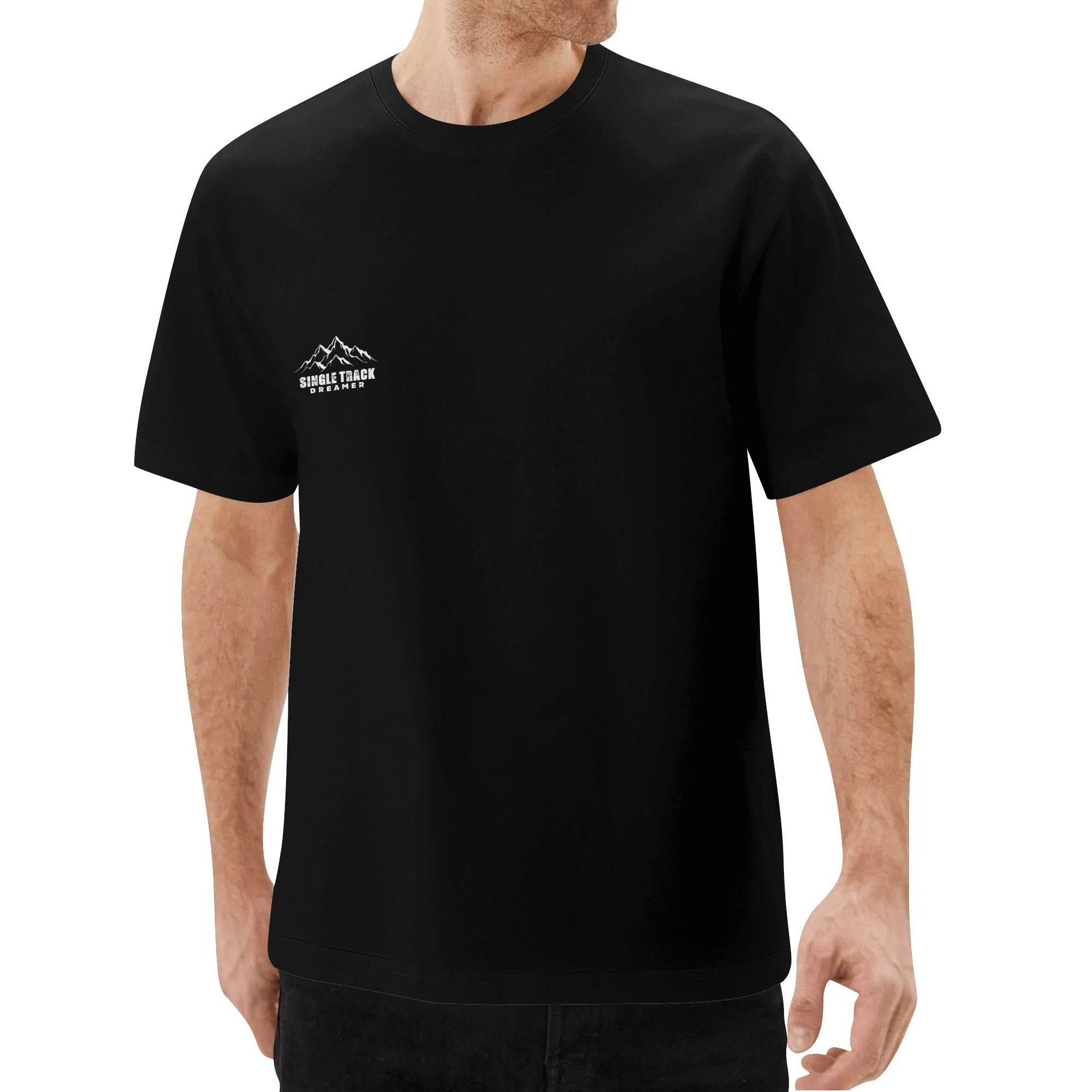 a man wearing a black t - shirt with a mountain scene on it
