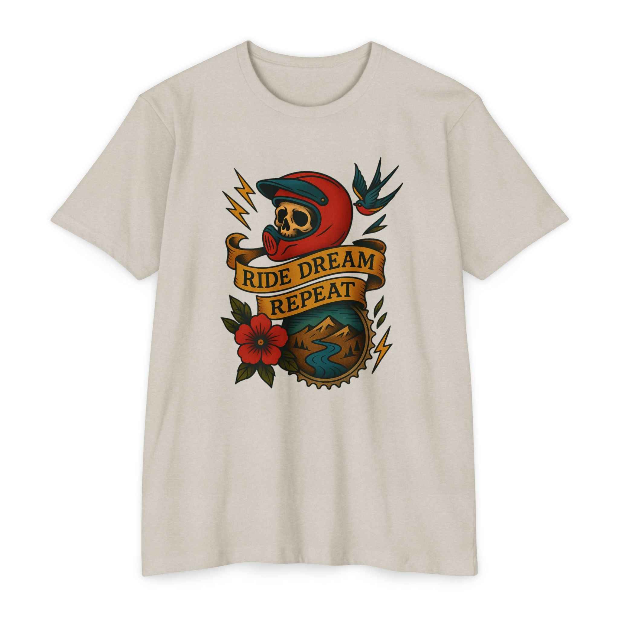Vintage Rider Spirit Tee in beige with skull helmet, lightning bolts, and 'Ride Dream Repeat' banner. Retro biker design for motorcycle enthusiasts.