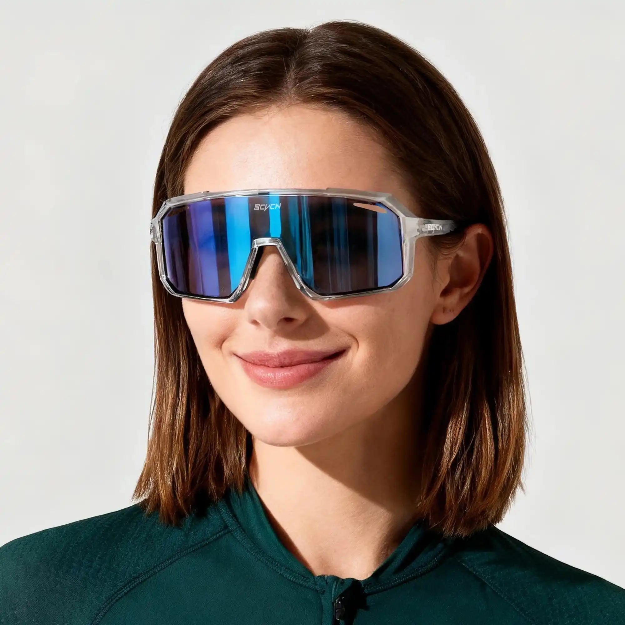 Woman wearing SCVCN photochromic cycling glasses with blue reflective lenses, designed for outdoor sports and UV protection.
